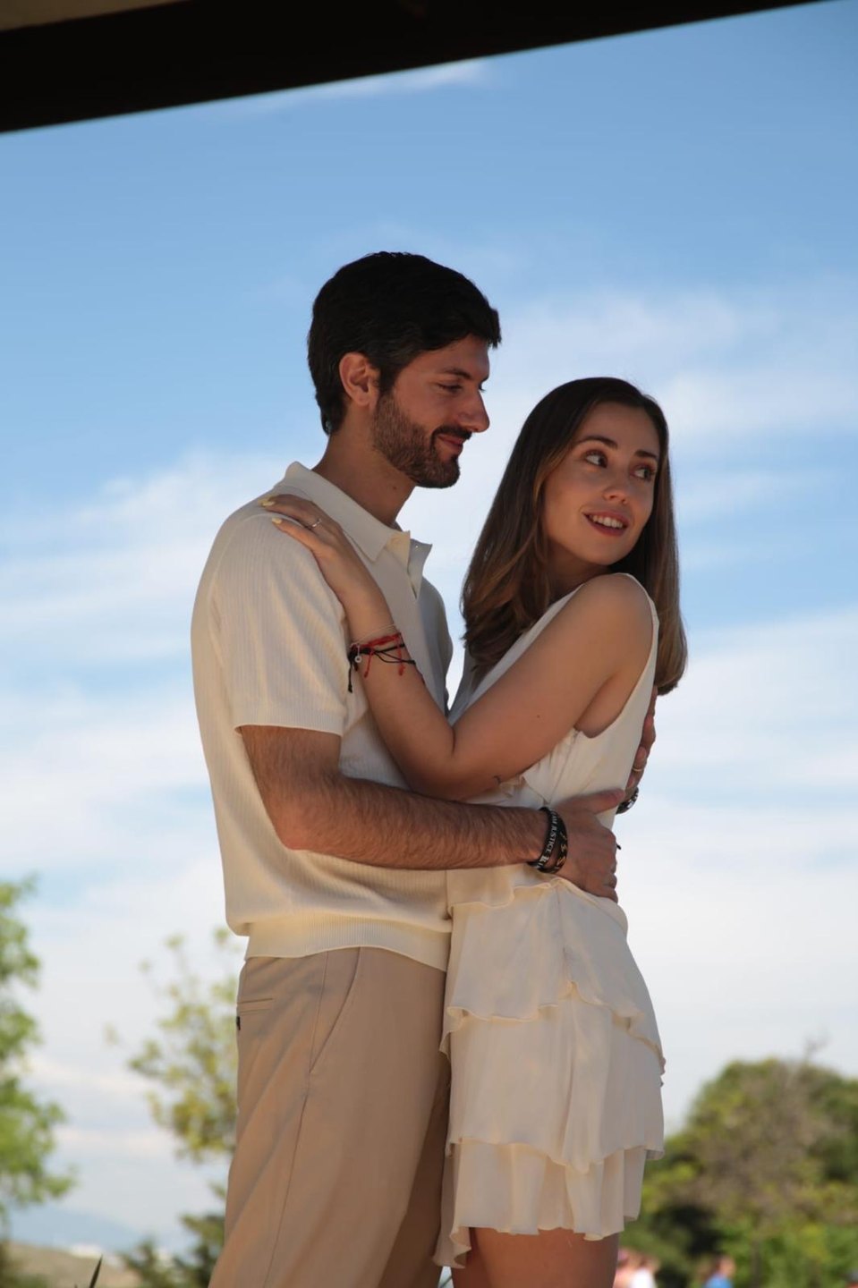 Henar y Álvaro abrazados bajo el cielo azul